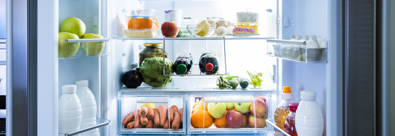 Photo of an open open french-doored fridge. The fridge is filled with fresh produce