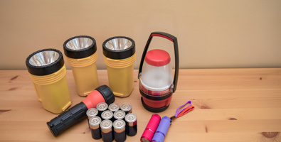 Flashlights and batteries laid out on a table prepared for a power outage.