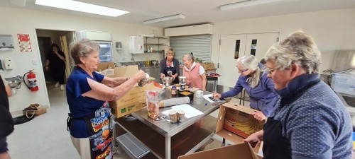 Lake Hāwea Community Centre kitchen a hive of activity, with volunteers preparing lunch packs for the contractors