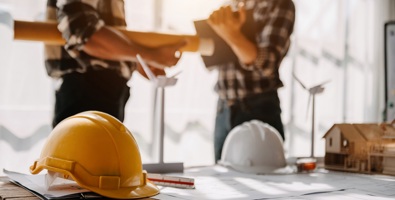 Construction team shake hands greeting start new project plan behind yellow helmet on desk in office to consults about their building project