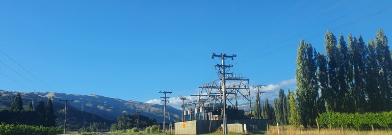 The Aurora Energy substation at Clyde on a blue sky day with mountains in the background