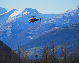 Helicopter flying with snowy mountains in the background