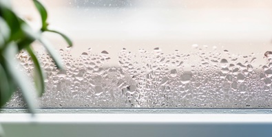 Photo of selective focus on water condensation on window glass showing home moisture. 