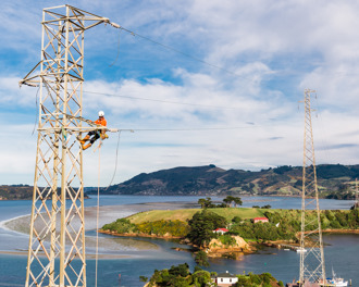 Worker up an electricity tower, removing conductor
