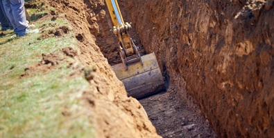 Excavator digs a trench for cables