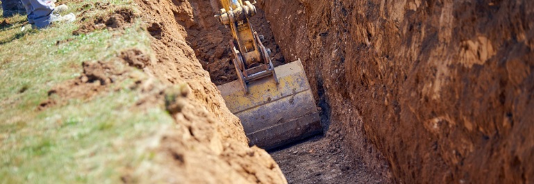Excavator digs a trench for cables