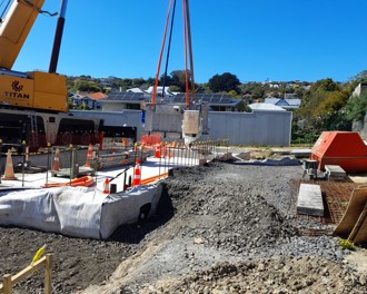 Image shows a crane moving transformer onto it's foundations.