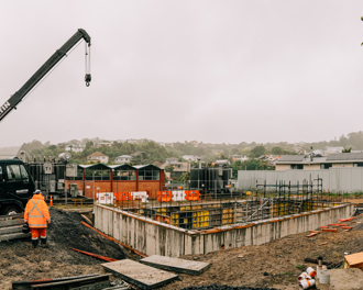 Another view of the construction site at the Anderson's Bay substation from December 2022. A crane to the left of the image, concrete foundations with steel framing is also visible. The original substation is in the background.